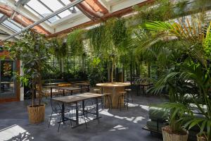 a conservatory with tables and chairs and plants at Combo Milano in Milan