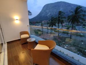 a room with a balcony with a view of a mountain at SILVER CLOUD in Nandigunda