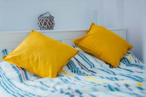 uma cama com duas almofadas amarelas em Rakoczi apartman 2 em Odorheiu Secuiesc