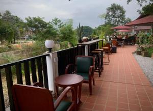 a row of tables and chairs on a balcony at River View Villas in Vang Vieng