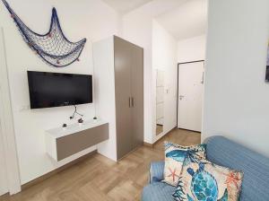 uma sala de estar com um sofá azul e uma televisão em Bilocale Clotilde seconda fila mare em San Benedetto del Tronto