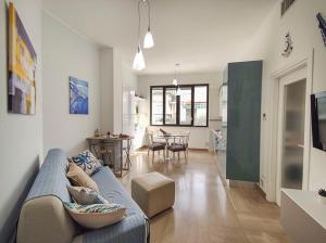 uma sala de estar com um sofá azul e uma cozinha em Bilocale Clotilde seconda fila mare em San Benedetto del Tronto