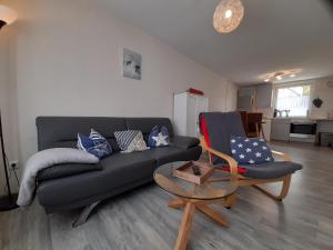 uma sala de estar com um sofá preto e uma mesa em Ferienwohnung Familie Kluge em Jemgum