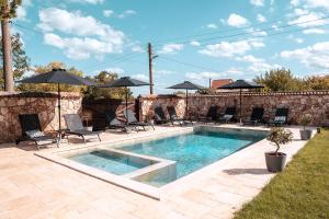 a swimming pool with chairs and umbrellas in a yard at Hotel Hunters House in Ezerets