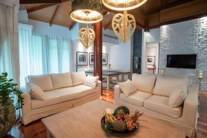 a living room with two white couches and a table at Villa in the Park, Whole house's suitable for family's vacation in Phuket