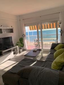 sala de estar con sofá y vistas al océano en Primera línea en Cullera con piscina. Inmejorables vistas en Cullera
