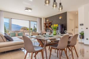 a dining room with a table and chairs and a couch at Villa SALVIA - new, modern villa near Split in Dugopolje