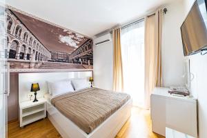 a bedroom with a bed with a painting on the wall at Riva City Rooms in Split