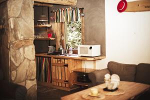 a kitchen with a counter with a microwave and a table at UROCZY DOMEK in Brenna
