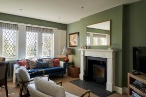 a living room with a blue couch and a mirror at ALTIDO The South Lodge at Balcarres in Colinsburgh