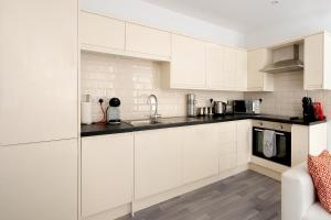 una cocina con armarios blancos y fregadero en Ipswich Town Centre - Apartment 7, en Ipswich