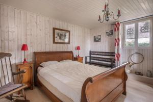 a bedroom with a bed and a chair in it at Golfe du Morbihan, Maison de charme pour 6 in Sarzeau