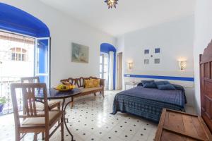 a bedroom with a bed and a table and a couch at La Estrella de Tarifa in Tarifa