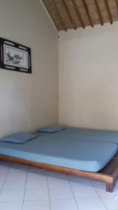 un letto in una camera con materasso blu di Gypsi Guest House a Pangandaran