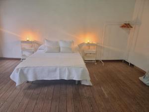 a bedroom with a white bed and two night stands at Km00 centro in Vallehermoso