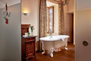 
a bathroom with a bath tub, sink, and mirror at Hotel Schloss Mittersill in Mittersill
