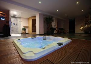 ナンシーにあるDs Plaisir Love Room avec sauna, jacuzzi à Nancyの客室の床に座ってジャグジータブが備わります。