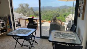 une femme assise à une table dans une pièce avec vue dans l'établissement B&B Casa Encantada, à Boliqueime