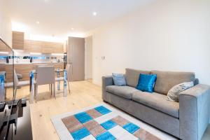 uma sala de estar com um sofá e uma mesa em Lovely 2 bed Condo London em Woolwich