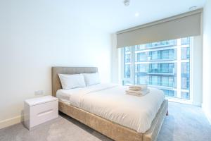 um quarto com uma cama e uma grande janela em Lovely 2 bed Condo London em Woolwich