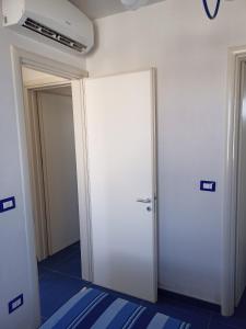 a white door in a room with two doors at Casa Vacanza in Torre San Giovanni Ugento