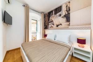 a bedroom with a bed and a tv on a wall at Riva City Rooms in Split +7 photos