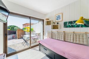 a bedroom with a pink bed and a balcony at Chez Pierrot in Bandol