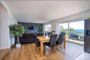 a dining room with a wooden table and black chairs at Crail 5 Bedroom Villa in Crail