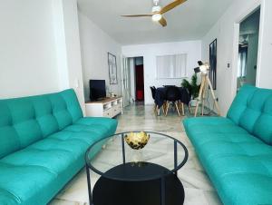 salon z 2 zielonymi kanapami i stołem w obiekcie BALCON PLAYA Y PISCINA 2 Habitaciones IPANEMA PONDOS w Almuñécar