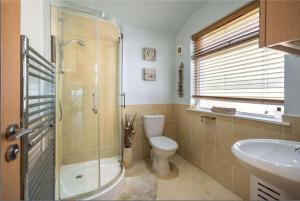 uma casa de banho com um WC, um chuveiro e um lavatório. em Crail 5 Bedroom Villa em Crail