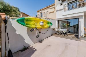 a yellow and green surfboard on the side of a house at Chez Pierrot in Bandol