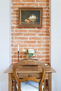 une chaise en bois assise devant un mur de briques dans l'établissement Chambres d’hôtes la guirosse, à Sainte-Eulalie-en-Born