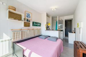 a bedroom with a pink bed and a kitchen at Chez Pierrot in Bandol