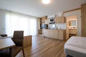 a room with a bed and a living room with a kitchen at Smart & Stay Aparthotel Saarlouis Lisdorf - Self-Check-In - Free Parking in Saarlouis