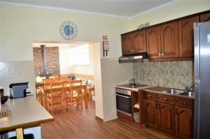uma cozinha com armários de madeira e uma sala de jantar em Casa Belos Ares em Ferrel