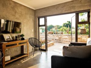 ein Wohnzimmer mit einem TV und einem Sofa in der Unterkunft Guest Room at Joubert in Piet Retief