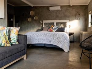 a bedroom with a large bed and a couch at Guest Room at Joubert in Piet Retief