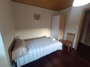 una camera con letto, sedia e armadio di CASA ISAURA DE PENA Camino Primitivo a Pacio