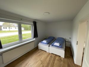 1 Schlafzimmer mit 2 Betten und einem Fenster in der Unterkunft Schleiblick App 14 in Rabenkirchen-Faulück