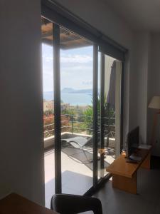 Zimmer mit Glasschiebetür zum Balkon in der Unterkunft Seametry Apartments in Souda