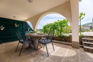 a table and chairs on a patio with a window at Apartment in Vrbnik/Insel Krk 36871 in Vrbnik