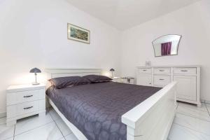 ein weißes Schlafzimmer mit einem großen Bett und weißen Schränken in der Unterkunft Apartment in Vrbnik - Insel Krk 36871 in Vrbnik