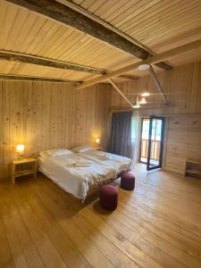 una camera da letto con un grande letto in una camera in legno di Hotel Chubezeni a Mestia