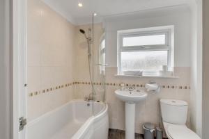 a bathroom with a sink and a toilet and a bath tub at Guest Homes - Galley Lodge in Norwich