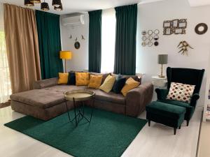 uma sala de estar com um sofá e uma cadeira em VillaGrey Tunari em Tunari