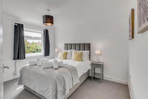 a white bedroom with a large bed and a window at Guest Homes - Galley Lodge in Norwich