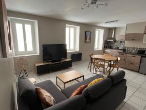 un soggiorno con un divano e un tavolo di bel appartement 2 chambres au coeur du village a Eyragues