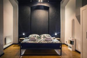 Ce lit se trouve dans un dortoir doté d'un mur noir. dans l'établissement Rynek No 3 APARTMENT, à Wałbrzych