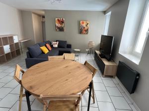 un soggiorno con un tavolo e un divano di bel appartement 2 chambres au coeur du village a Eyragues