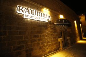 聖露法的住宿－Kaliruha Boutique Hotel，砖楼边的标志